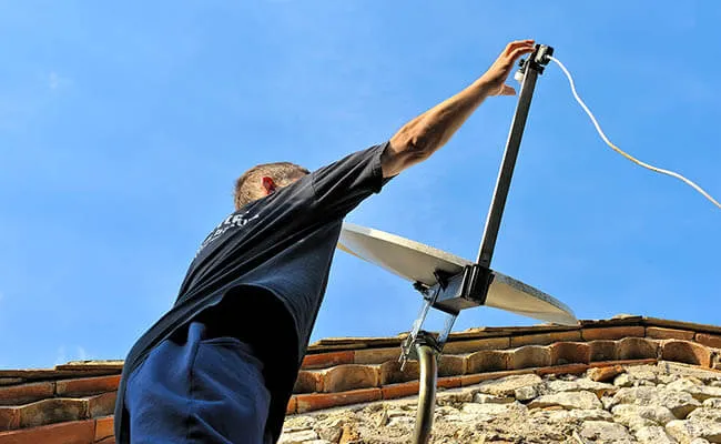 Technicien antenniste réglant une antenne TV